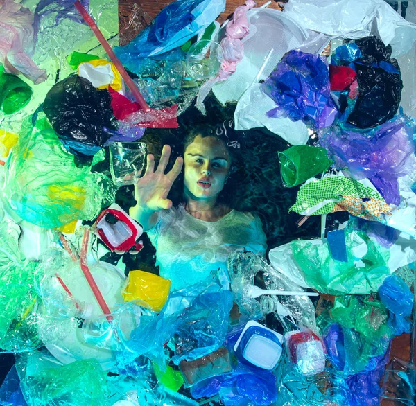 塑料接受者堆下的海水中溺水妇女，环境概念 — 图库照片