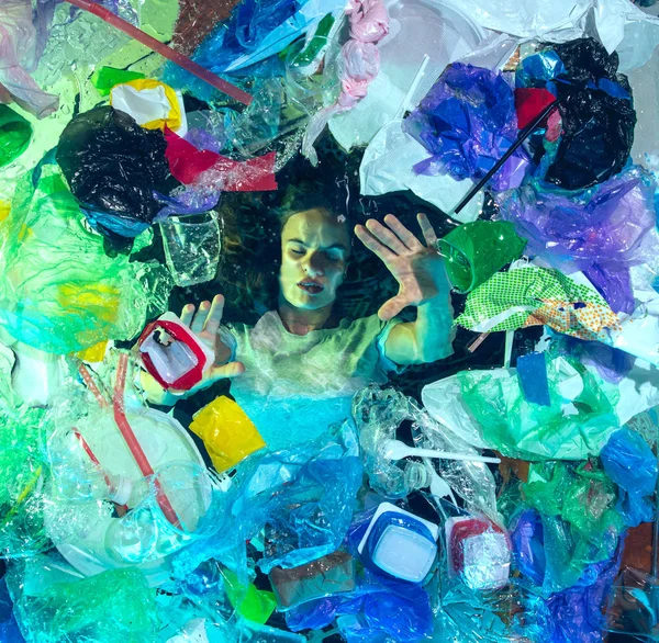 Donna che annega nell'acqua dell'oceano sotto plastica recipienti mucchio, concetto di ambiente — Foto Stock