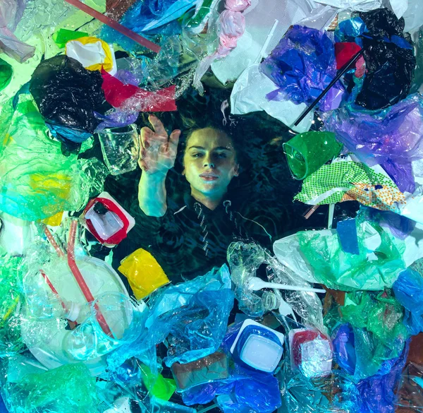 Donna che annega nell'acqua dell'oceano sotto plastica recipienti mucchio, concetto di ambiente — Foto Stock