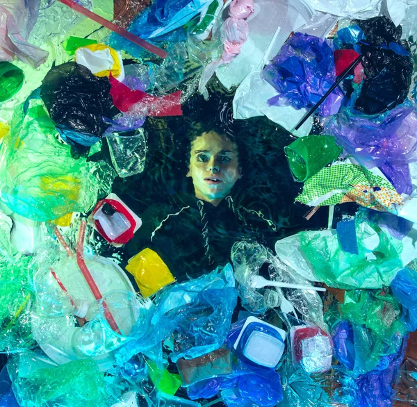 Nő fuldokló óceáni víz alatt műanyag címzettek halom, környezetvédelmi koncepció — Stock Fotó