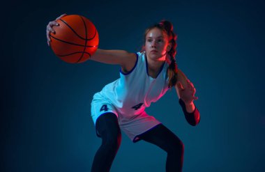 Mavi stüdyo arka planında beyaz kadın basketbolcu neon ışıklarıyla
