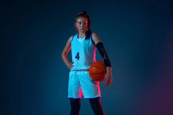 Giovane giocatore di basket femminile caucasico su sfondo blu studio in luce al neon — Foto Stock