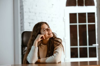 Gündelik giysiler içinde genç beyaz bir kızın portresi hayal dolu ve mutlu görünüyor.