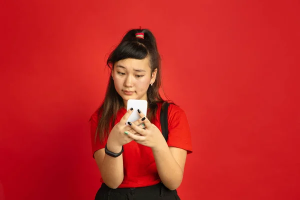 Asijské teenageři portrét izolovaný na červeném pozadí studia — Stock fotografie