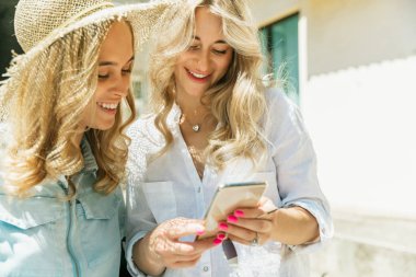 Genç lezbiyençift güneşli bir günde arabada tatil gezisi için hazırlanıyor