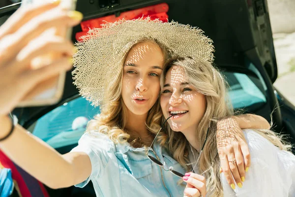 Jovens lésbicas casal se preparando para viagem de férias no carro em dia ensolarado — Fotografia de Stock