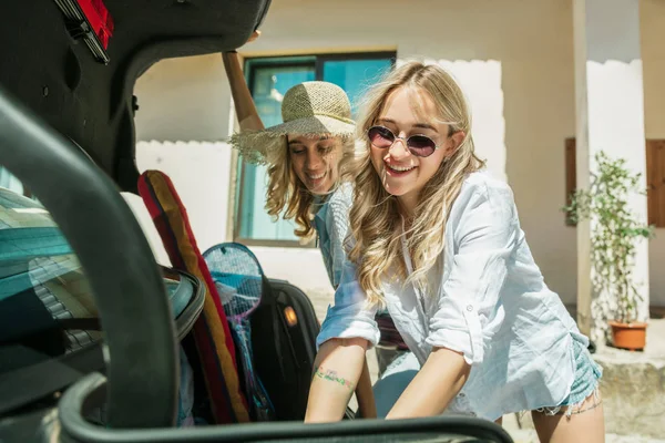 Jovens lésbicas casal se preparando para viagem de férias no carro em dia ensolarado — Fotografia de Stock