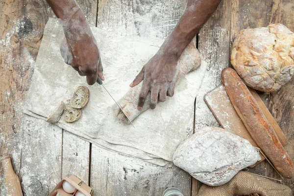 Vista superior do homem afro-americano cozinha pão na cozinha artesanal — Fotografia de Stock