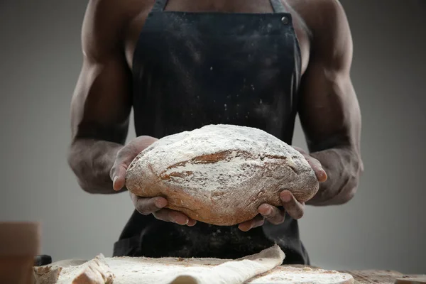 Крупным планом афро-американец готовит хлеб на ремесленной кухне — стоковое фото