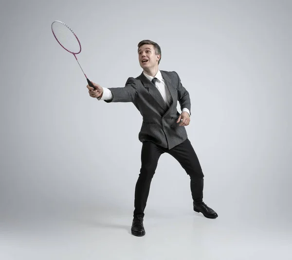 Caucásico hombre en oficina ropa juega bádminton aislado en gris estudio fondo —  Fotos de Stock