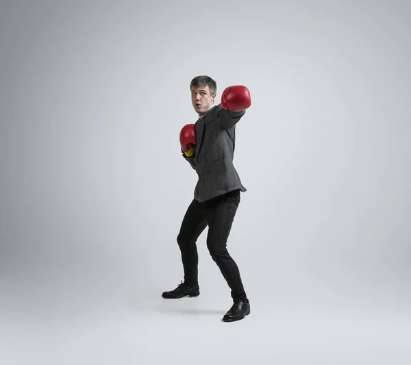 Homem caucasiano em roupas de escritório boxe isolado em fundo estúdio cinza — Fotografia de Stock