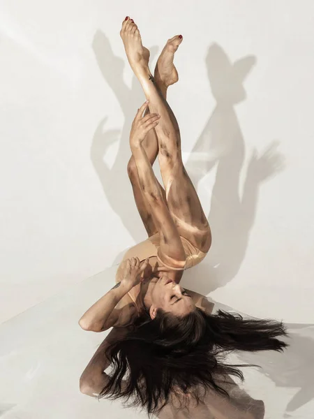 Jovem e elegante bailarino moderno no fundo branco com espelhos — Fotografia de Stock