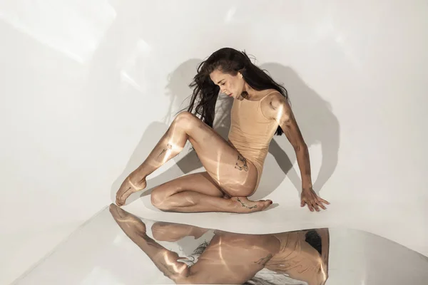 Joven y elegante bailarina de ballet moderna sobre fondo blanco con espejos —  Fotos de Stock