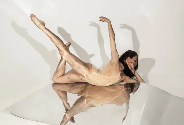 Joven y elegante bailarina de ballet moderna sobre fondo blanco con espejos —  Fotos de Stock