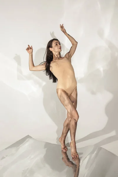 Молодой и стильный современный артист балета на белом фоне с зеркалами — стоковое фото