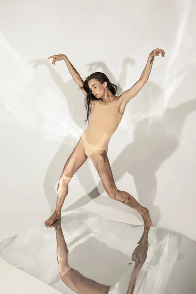 Молодой и стильный современный артист балета на белом фоне с зеркалами — стоковое фото
