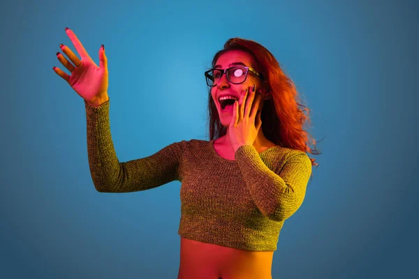 Kaukasische Frauen Porträt isoliert auf blauem Studiohintergrund in Neonlicht — Stockfoto