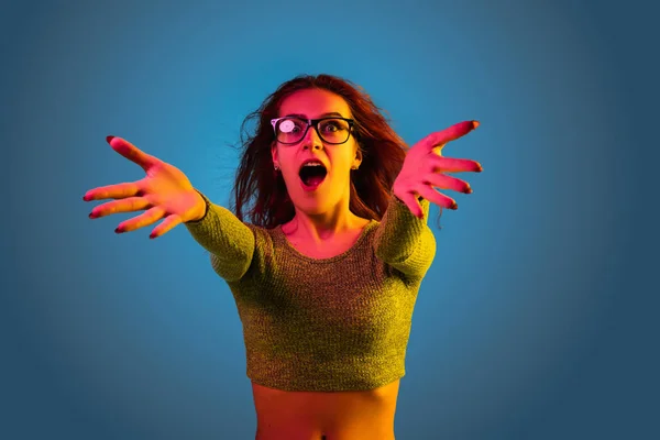 Mulheres caucasianas retrato isolado em fundo estúdio azul em luz de néon — Fotografia de Stock