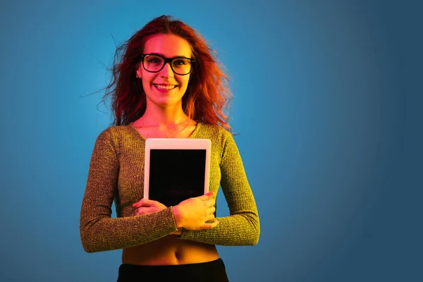 Caucasian womans portrait isolated on blue studio background in neon light — Stock Photo, Image