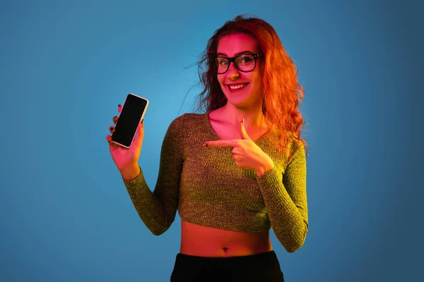 Caucasian womans portrait isolated on blue studio background in neon light — Stock Photo, Image