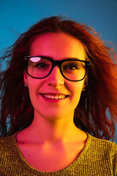 Kavkazské ženy portrét izolované na modrém pozadí studia v neonovém světle — Stock fotografie