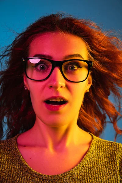 Kaukasische Frauen Porträt isoliert auf blauem Studiohintergrund in Neonlicht — Stockfoto