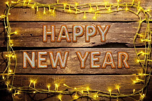 New Year wishes made of cakes on wooden table background