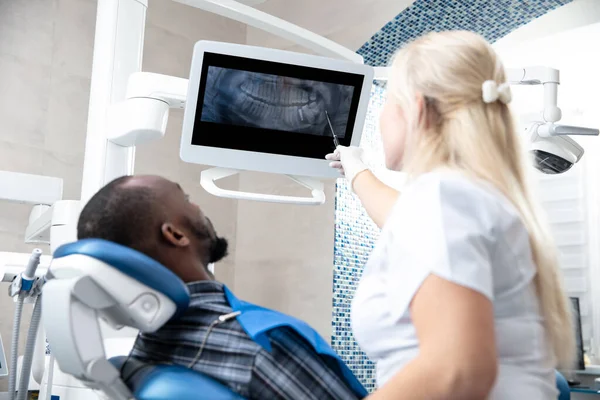 Hombre afroamericano joven visitando consultorio de dentistas — Foto de Stock