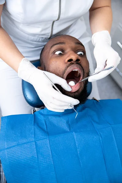 Jovem homem afro-americano visitando dentistas escritório — Fotografia de Stock
