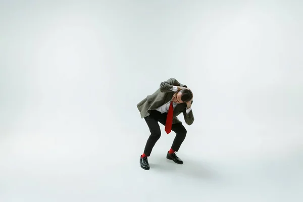 Jovem caucasiano homem em movimento flexível no fundo do estúdio branco — Fotografia de Stock