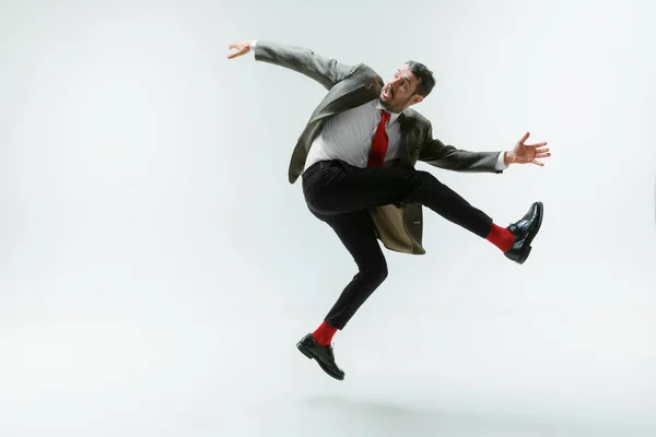 Jeune homme caucasien se déplaçant flexible sur fond de studio blanc — Photo