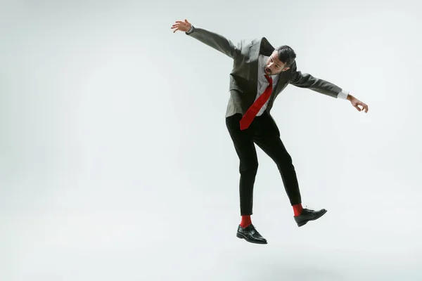 Joven caucásico hombre moviéndose flexible en blanco estudio fondo — Foto de Stock