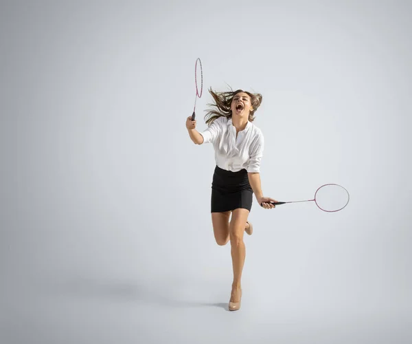 Fehér nő irodai ruhák játszik tollaslabda elszigetelt szürke stúdió háttér — Stock Fotó