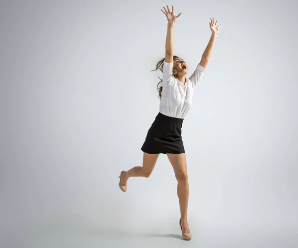 Donna caucasica in abiti da ufficio cattura palla isolato su sfondo grigio studio — Foto Stock