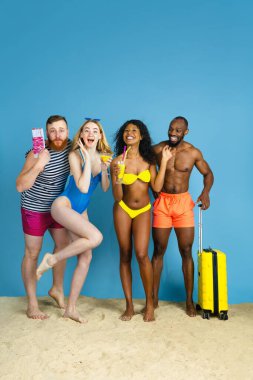 Mutlu genç arkadaşlar mavi stüdyoda dinleniyor.