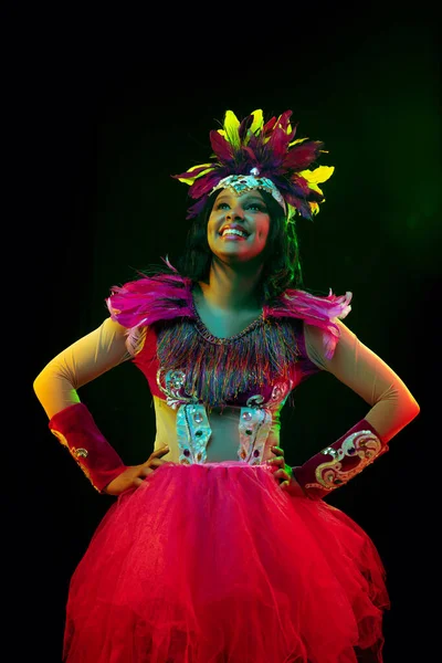 Mulher bonita em máscara de carnaval e traje de mascarada em luzes coloridas — Fotografia de Stock