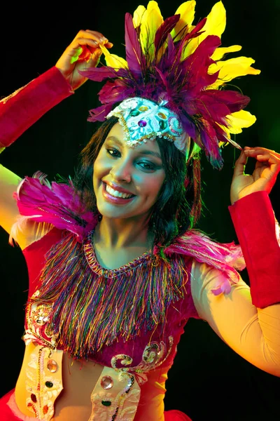 Piękna młoda kobieta w masce karnawałowej i kostium maskowy w kolorowe światła — Zdjęcie stockowe