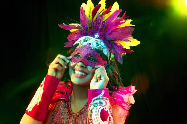 Красивая молодая женщина в карнавальной маске и маскарадный костюм в ярких огнях — стоковое фото