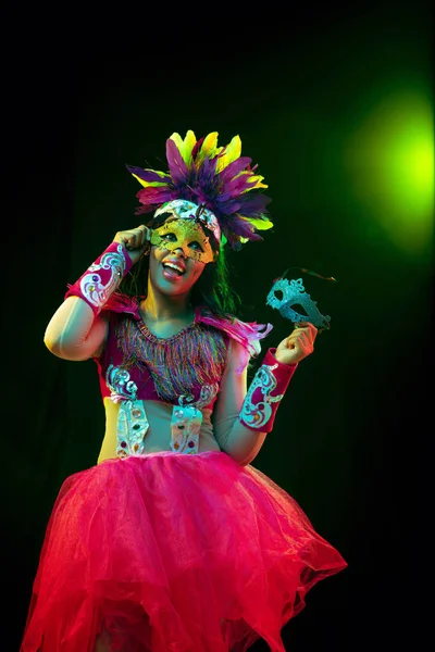 Mulher bonita em máscara de carnaval e traje de mascarada em luzes coloridas — Fotografia de Stock