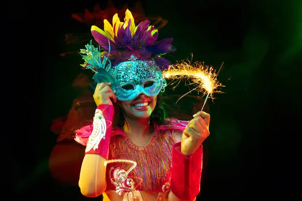 Vacker ung kvinna i karneval mask och maskerad kostym i färgglada ljus — Stockfoto