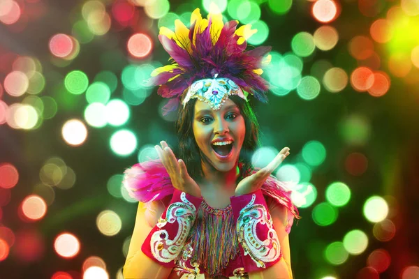 Mooie jonge vrouw in carnaval masker en maskerade kostuum in kleurrijke lichten — Stockfoto