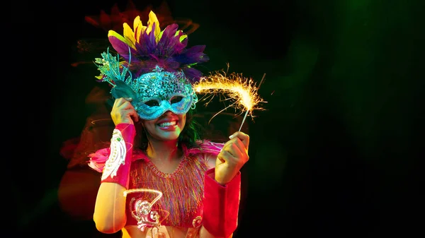 Gyönyörű fiatal nő karnevál maszk és álarcosbál jelmez színes fények, szórólap — Stock Fotó