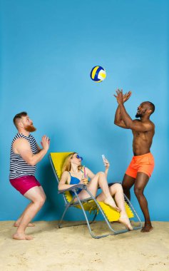 Mutlu genç arkadaşlar mavi stüdyoda dinleniyor.