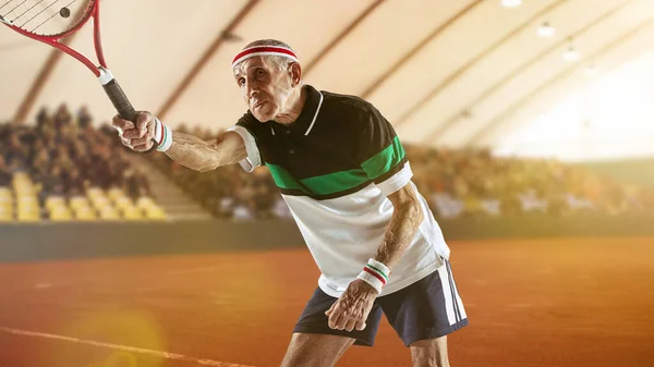 Homem sênior jogando tênis em sportwear no estádio — Fotografia de Stock