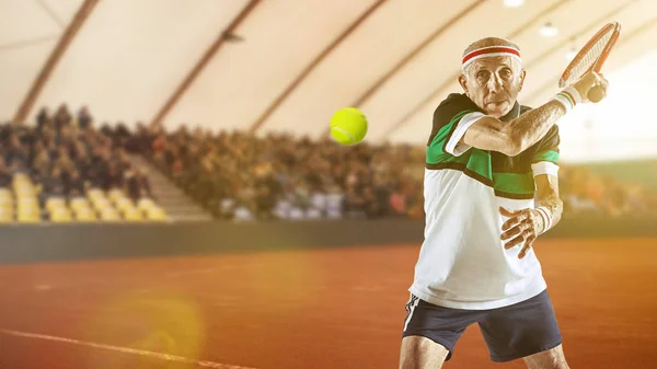 Homem sênior jogando tênis em sportwear no estádio — Fotografia de Stock