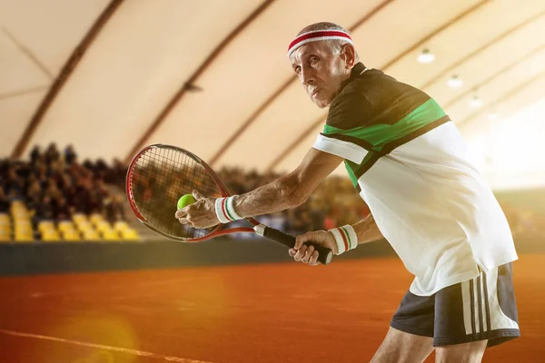 Homem sênior jogando tênis em sportwear no estádio — Fotografia de Stock