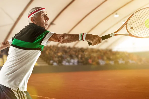 Homme âgé jouant au tennis dans les vêtements de sport sur le stade — Photo