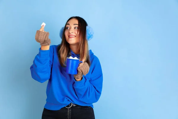 Kaukasiska kvinnor porträtt isolerad på blå studio bakgrund, vinter tema — Stockfoto