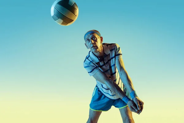 Senior spielt in Sportbekleidung auf Steigungsuntergrund und Neonlicht Volleyball — Stockfoto