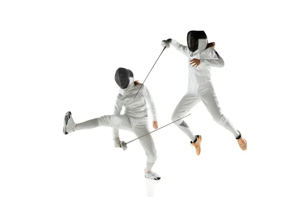 Девушки-фехтовальщики в костюмах с мечами в руках изолированы на белом фоне — стоковое фото